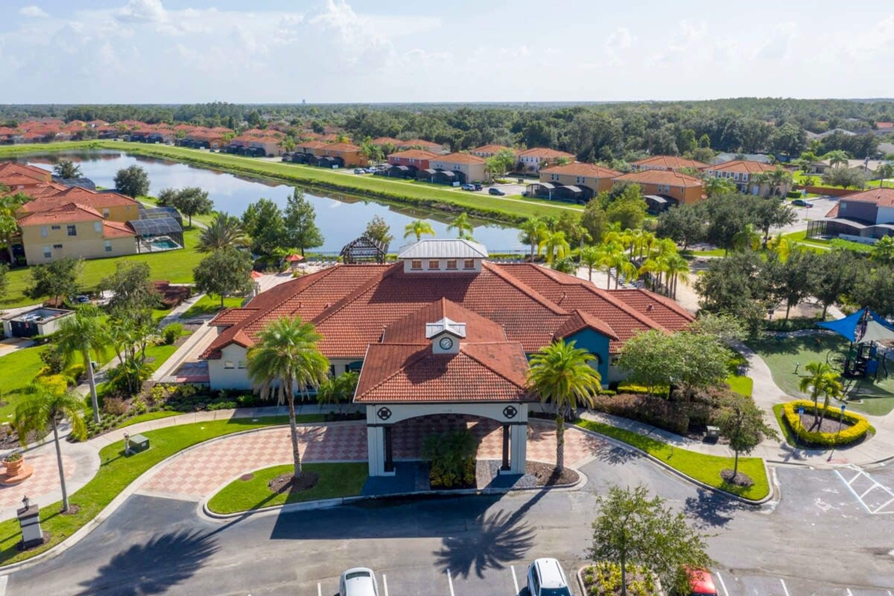 A gated community with a central pavilion, a body of water, and surrounding houses.
