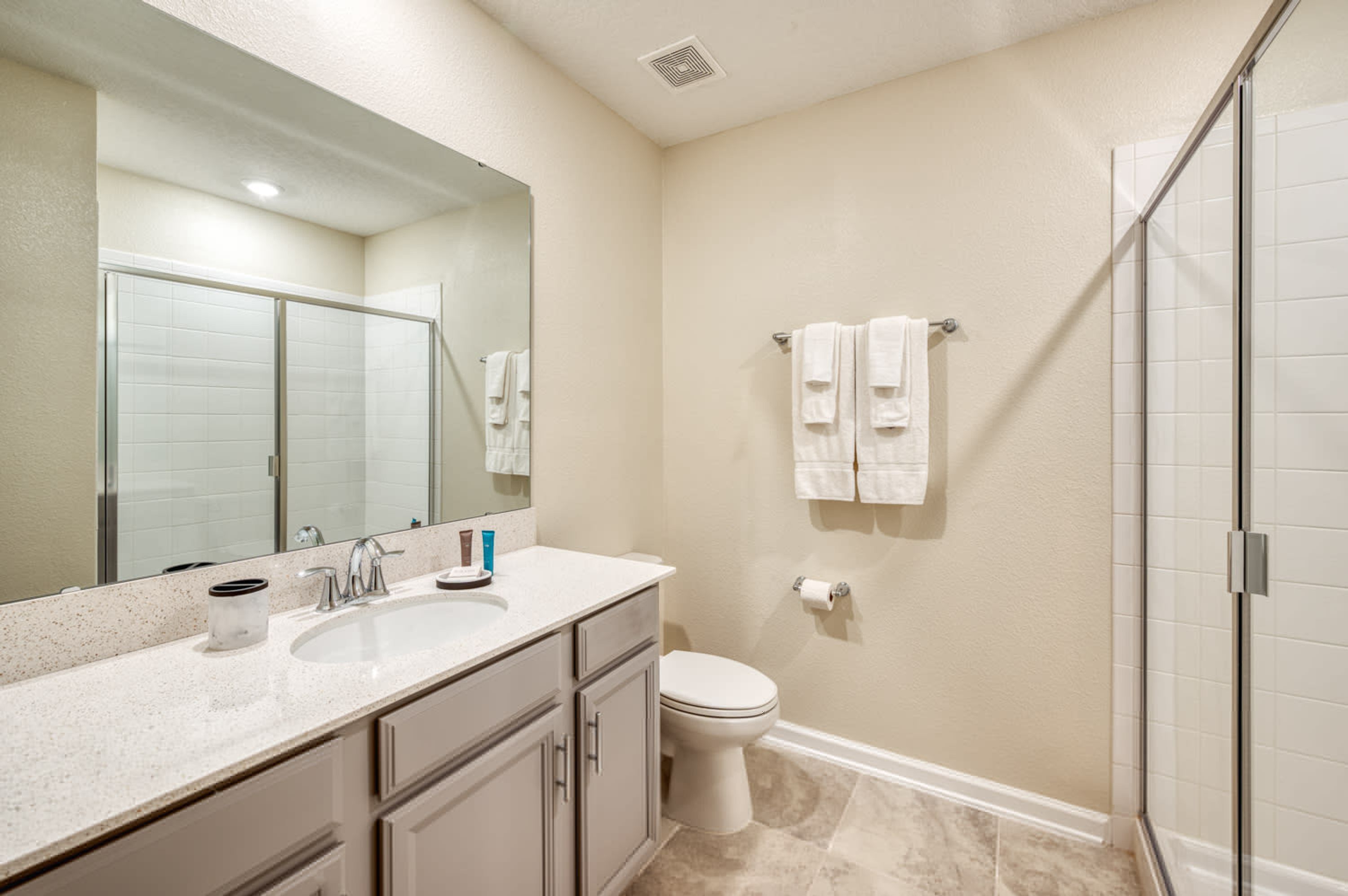 Une salle de bain équipée d’un lavabo, d’un miroir, de toilettes et d’une douche.