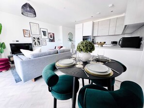 Relax in this stylish living space with a comfortable sofa, dining table, and modern kitchen.