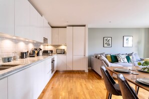 Enjoy meals in the kitchen with stainless steel sink and range hood, then dine at the wooden table for two.