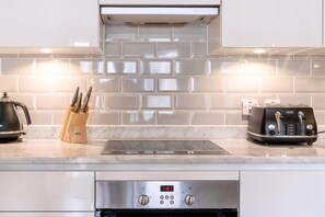 Enjoy cooking in this well-equipped kitchen with a stovetop, toaster, and stainless steel range hood.