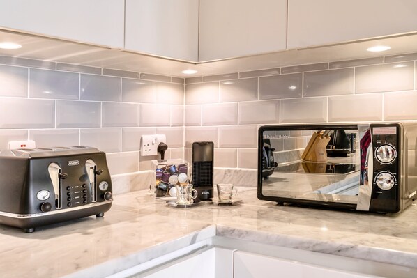 Enjoy cooking in this well-equipped kitchen with a coffee maker, toaster, and large mirror.