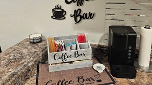 Een keukenblad met een koffiebar, inclusief een koffiezetapparaat, een koffiekop en een bordje met de tekst 'Coffee Bar'.