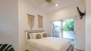 A bedroom with a bed, a window, and a ceiling fan. - Sunset Cottage - Pet Friendly- Oceanstays (Yamba)