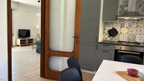 A modern kitchen with grey cabinets, a stainless steel stove, and a patterned backsplash. - Casa La Pigna in Pisa (Pisa)