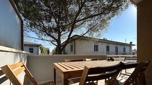 A wooden table and chairs on a balcony with a view of a tree and buildings in the background. - Casa La Pigna in Pisa (Pisa)