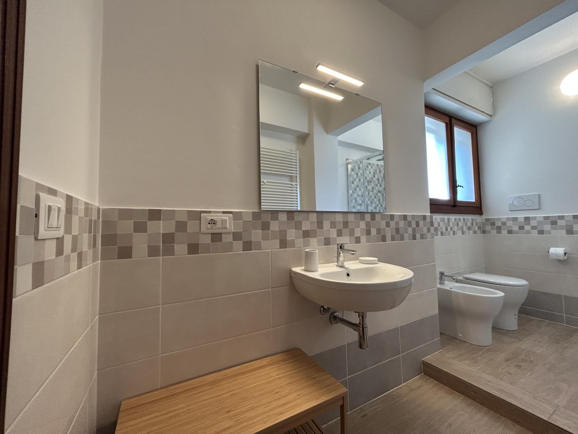 Une salle de bain moderne avec un lavabo, un miroir et des toilettes.