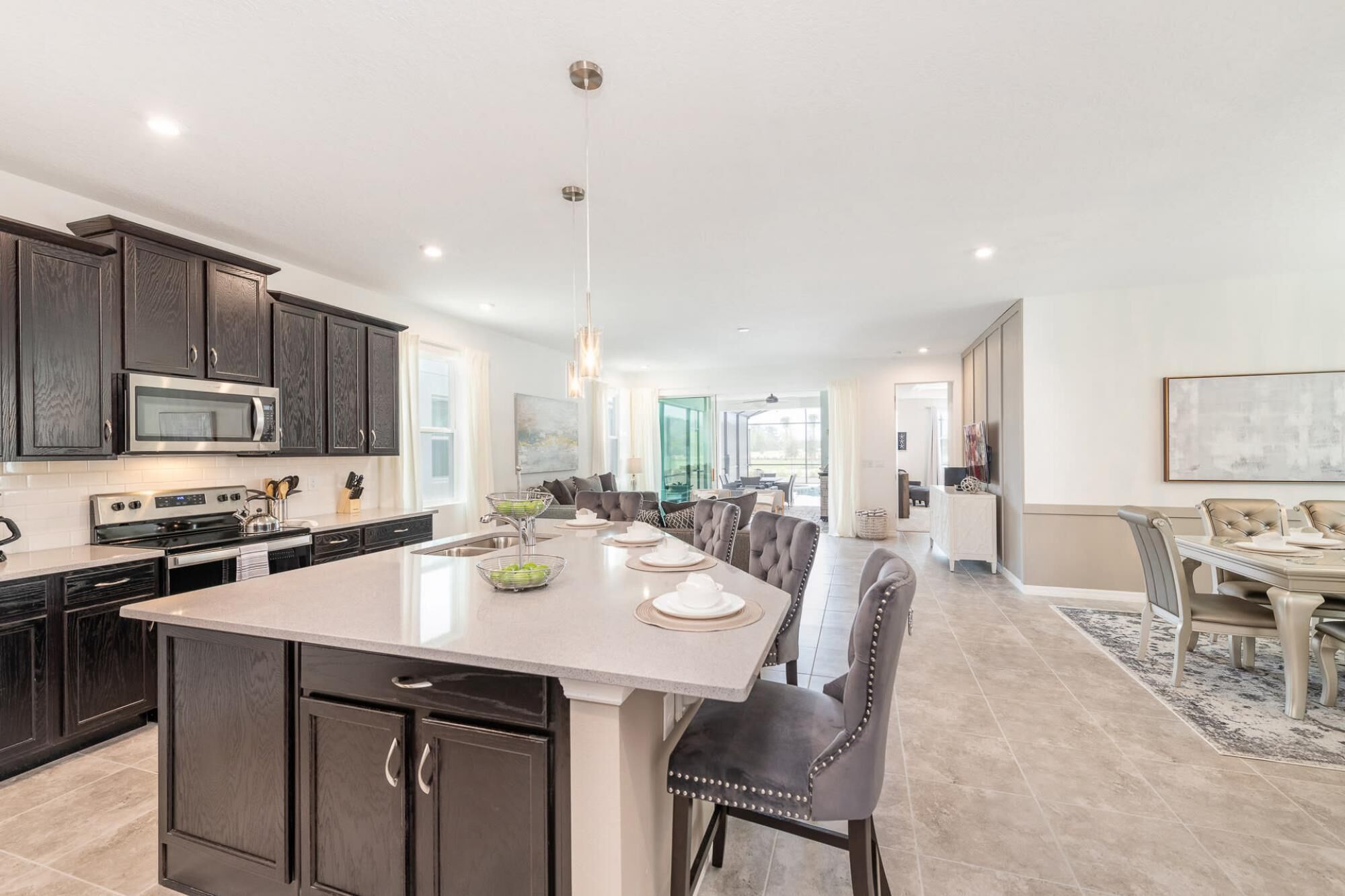 A spacious kitchen with dark wood cabinets, a large island, and a dining area with a long table and chairs.