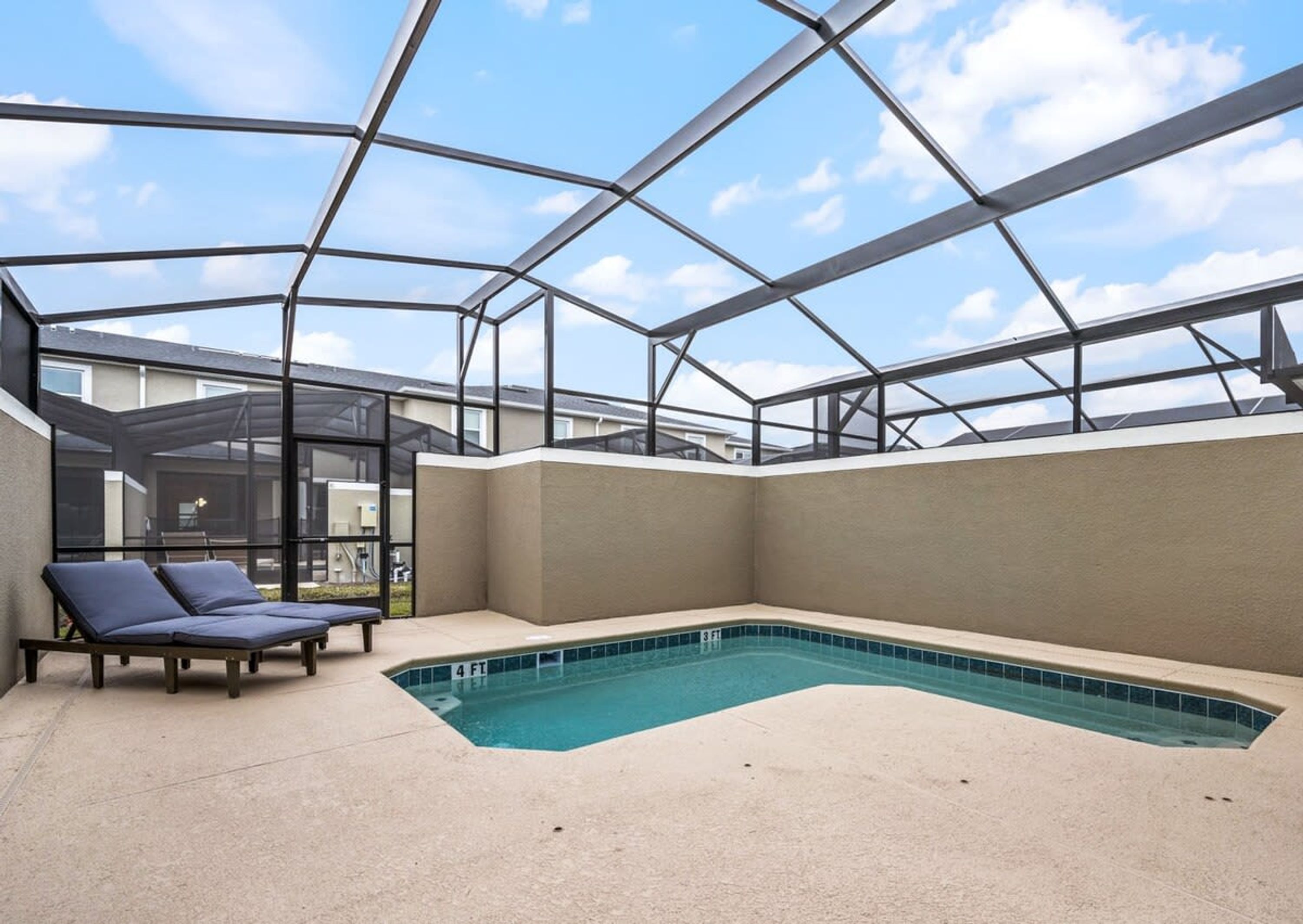 Una piscina esterna coperta con lettini, un'area vetrata e vista sul cielo.