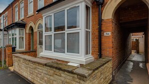 A row of terraced houses with a bay window on the front. - Heathcoat Apartment with Courtyard (Leicestershire)