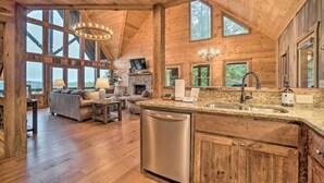Un intérieur de chalet en bois spacieux, comprenant une cuisine, un coin repas et un salon.