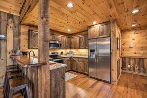 Une cuisine dotée de meubles en bois, d’appareils électroménagers en acier inoxydable et d’un plan de travail en granit.