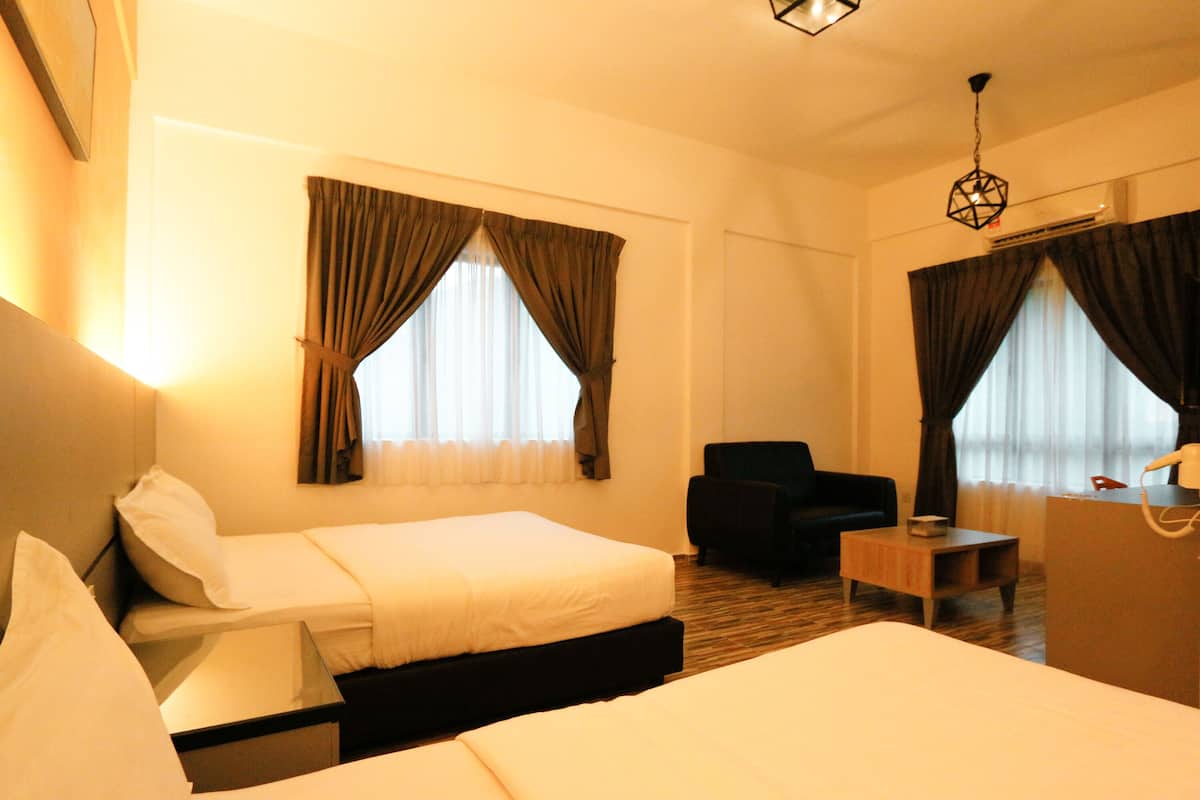 A hotel room with two beds, a desk, a chair, and a small table.