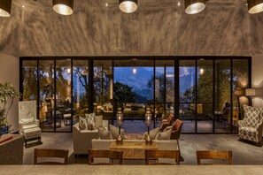 A modern interior with a seating area, large windows, and a view of the outdoors.