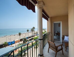 A balcony with a view of the beach and ocean.