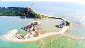 An aerial view of a coastal area with clear water, sandy beaches, and a small island with industrial structures. - Cape Pakarang Wow Wild Wellness Escapes (Khao Lak)