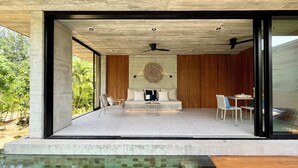 Un espace de vie extérieur moderne comprenant une piscine, un canapé et une table à manger.