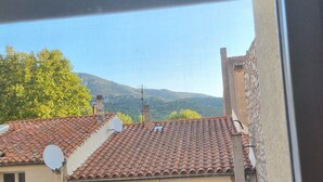 Vista di un edificio residenziale con tetto in tegole, diverse finestre e un'antenna parabolica.