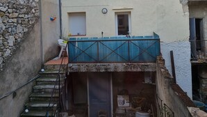 Un cortile con una scala che conduce a un balcone al secondo piano.