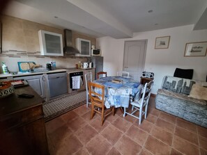 Une cuisine équipée d’une table à manger, de chaises, d’un four à micro-ondes, d’une cuisinière et d’un évier.