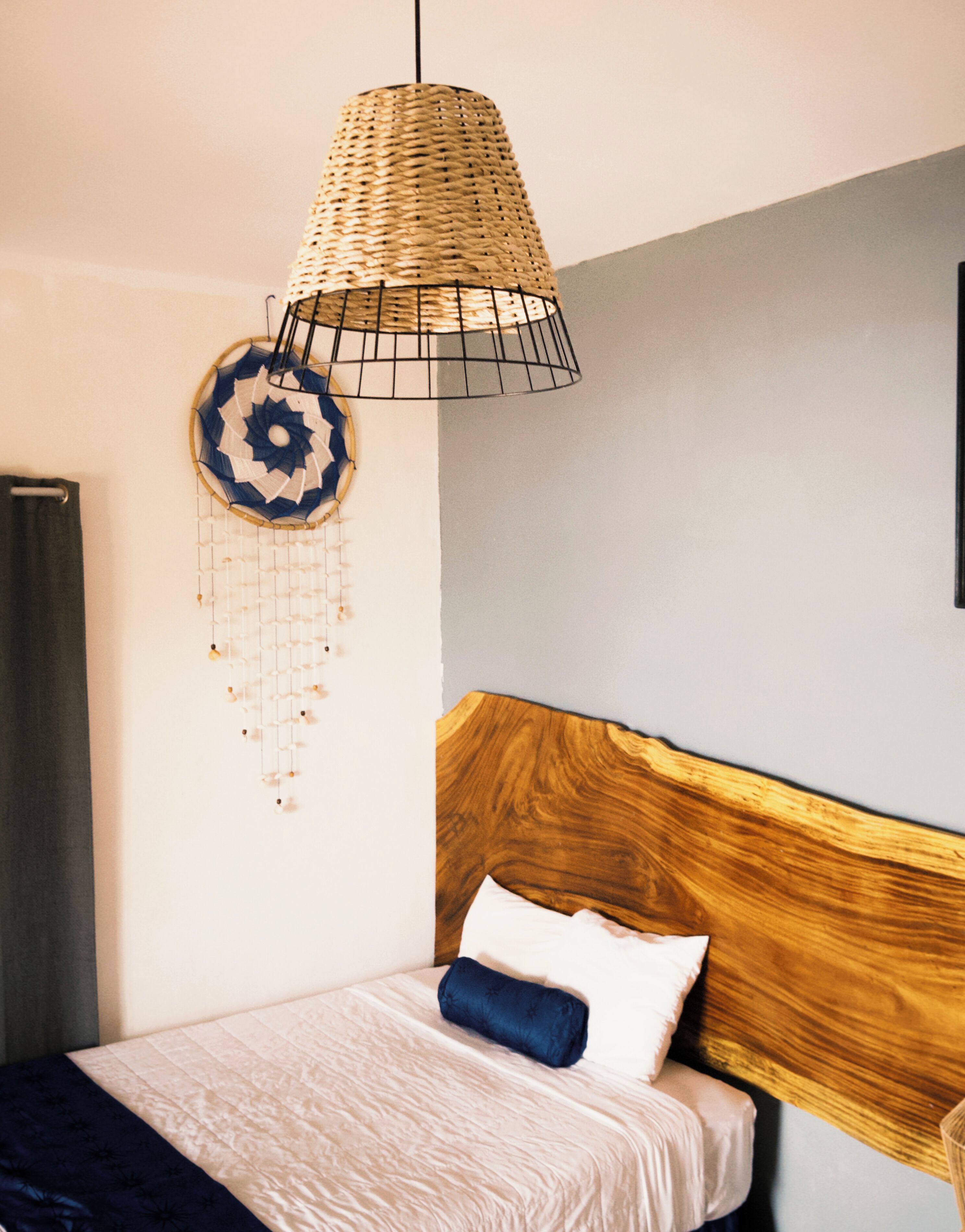 Un dormitorio con una cama, una lámpara colgante y un adorno en la pared.