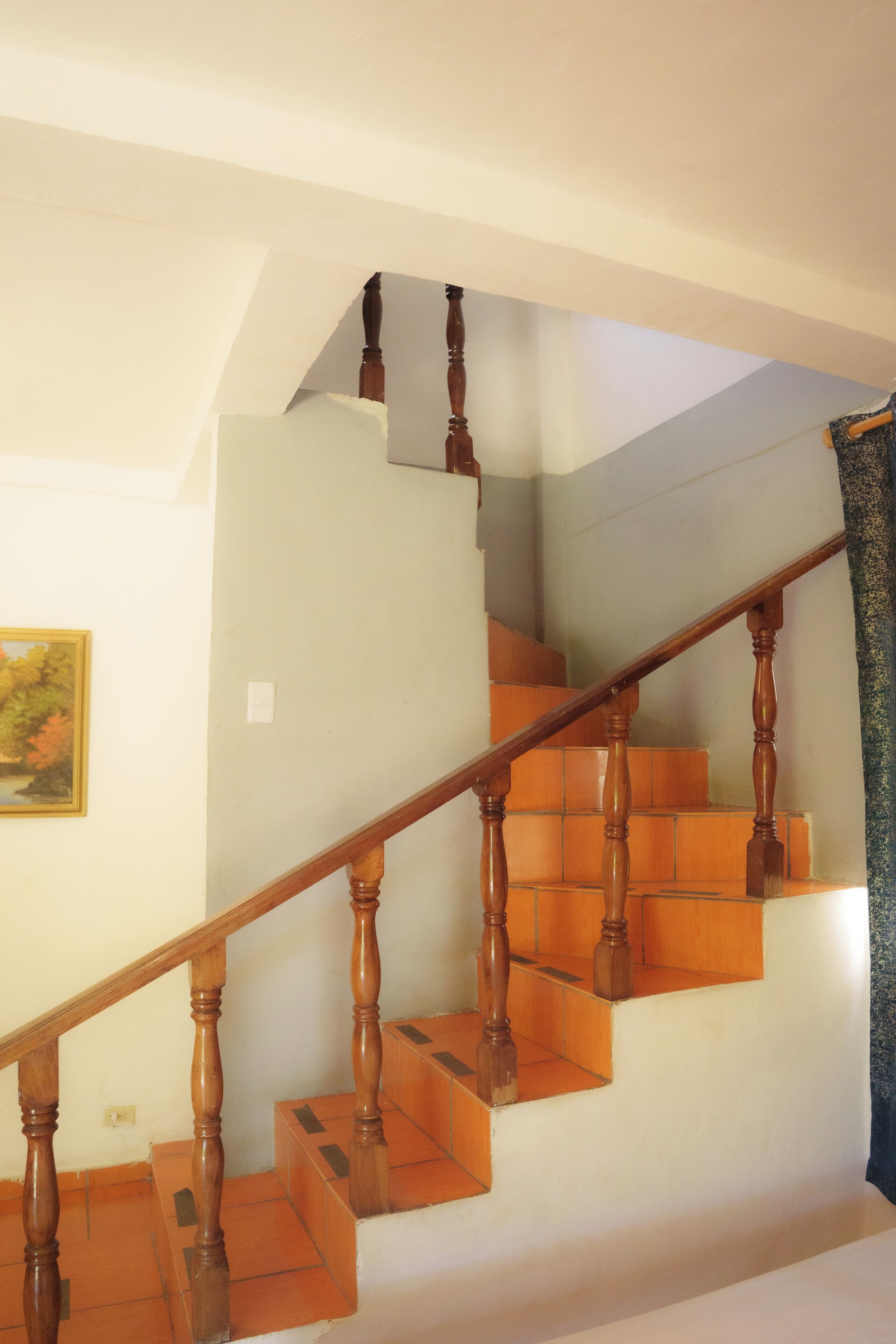 A wooden staircase with a handrail, leading to an upper floor.