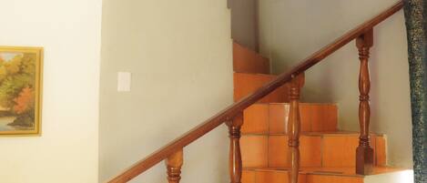A wooden staircase with a handrail, leading to an upper floor.