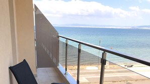 Un balcón con vista al mar y la costa lejana.