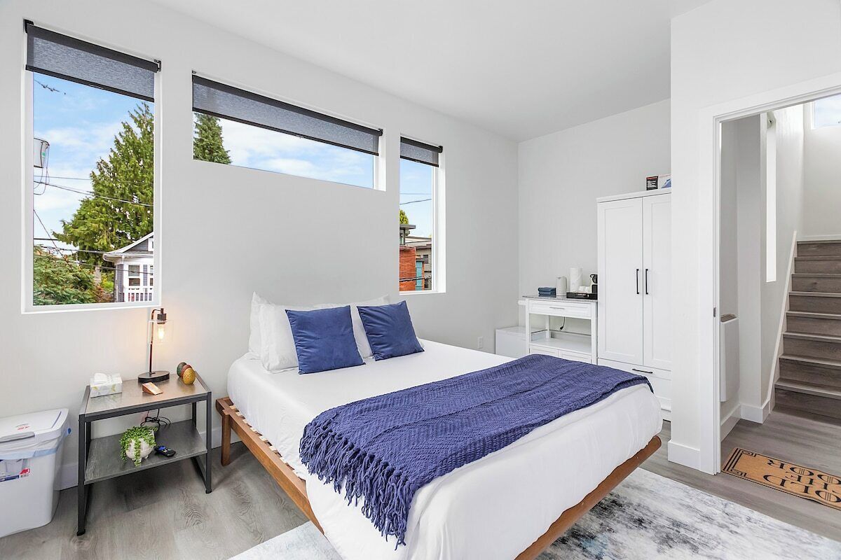 Een moderne slaapkamer met een groot bed, een nachtkastje, een bureau en een kledingkast.