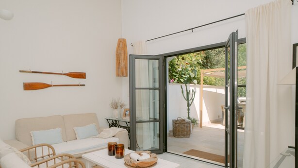A modern living room with a sofa, chairs, a table with a basket, and two wooden paddles on the wall. - Holiday Home 'Casa Familia' with Private Pool, Wi-Fi and Air Conditioning (Sa Pobla)