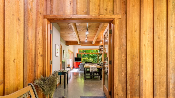 A wooden interior with a bench, a table, and a green wall. - Rhythm Waters by AvantStay | Garden Paradise, Pond (Langley)