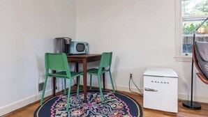 A corner room with a small table, two green chairs, a radio, and a white Galanz refrigerator. - Quick Drive To Ft. Jackson, King, Full Bath, (Columbia)