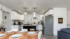A modern kitchen with white cabinets, a central island, and pendant lighting. - Twin Oaks Retreat by AvantStay | Mins to Freeland (Freeland)