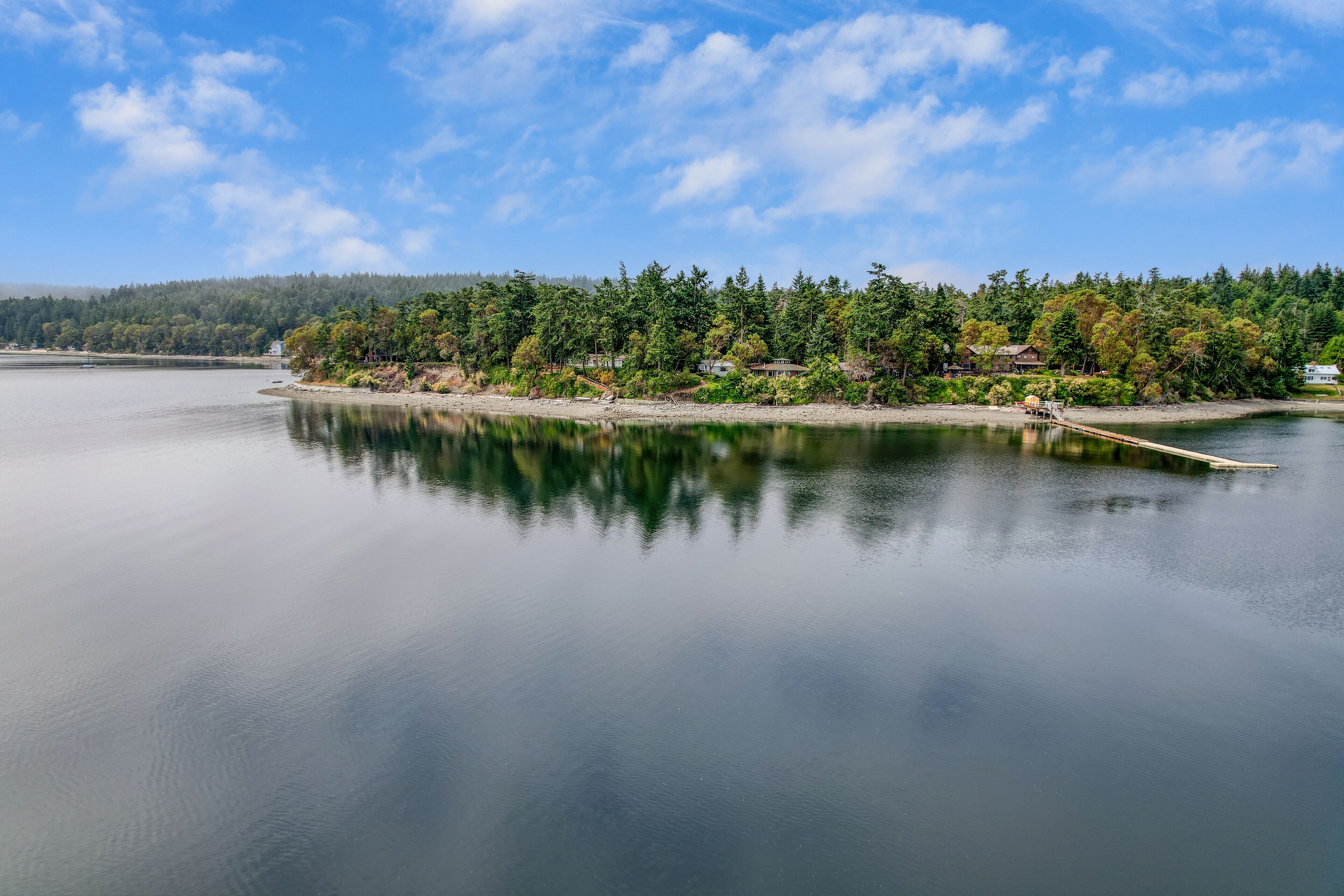 A calm lake with a wooden dock extending into the water.