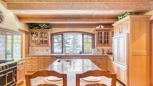 A spacious kitchen with wooden cabinets, a large island, and a view of the outdoors.