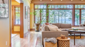 A spacious living room with a large window, a potted plant, and a cozy seating area.