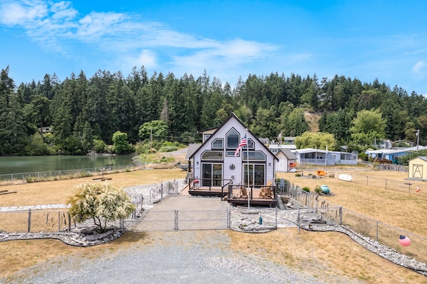 Situated on a grassy area, this charming building features a gabled roof and a prominent American flag.