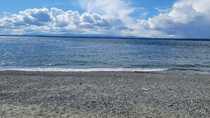 A pebbled beach with a clear sky and distant mountains. - Lagoon Point Retreat • Beach Access + Fire Pit + Game Room | Chateau Coho (Greenbank)
