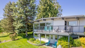 A two-story house with a balcony, a covered patio, and a well-maintained garden. - Sunny Side Island Retreat by AvantStay | Backyard (Freeland)