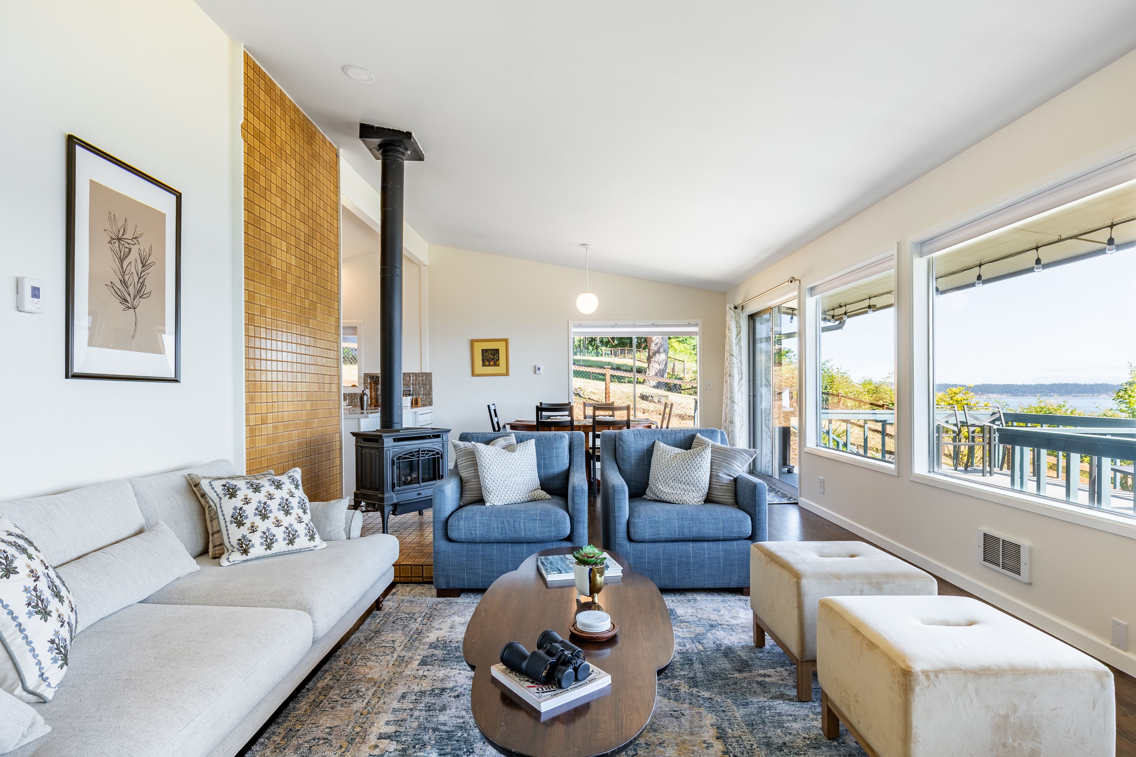 Una sala de estar moderna con un sofá, dos sillones, una mesa de centro y una chimenea.