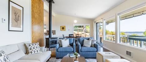 Una sala de estar moderna con un sofá, dos sillones, una mesa de centro y una chimenea.
