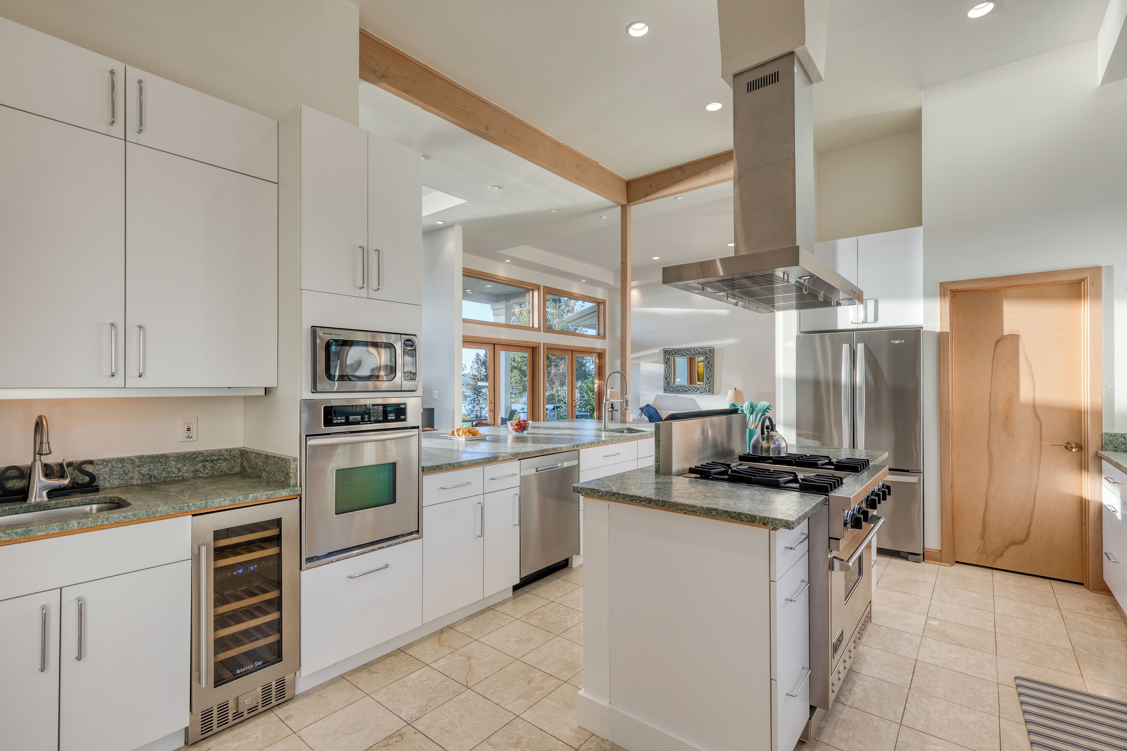Una cocina moderna con armarios blancos, electrodomésticos de acero inoxidable y una isla grande.