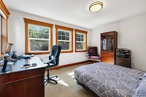 A bedroom with a bed, a desk with a computer, a chair, and a cabinet. - Waterfront + Patio + Saratoga Views | Mins to Langley | Cascade View Haven (Langley)
