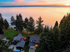 A residential area with houses, a lawn, and a body of water in the background. - Waterfront + Patio + Saratoga Views | Mins to Langley | Cascade View Haven (Langley)