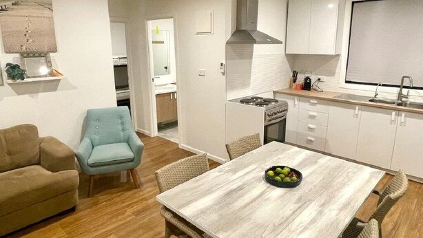 Un espacio habitable compacto con comedor, kitchenette y sofá.