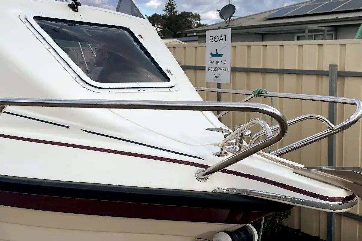 Un bote con baranda metálica y un letrero que indica 'Boat Parking Reserved'.