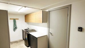 Cocina compacta con lavavajillas, una pequeña encimera y armarios de madera.