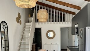 Una cocina moderna con horno empotrado y un comedor con mesa y sillas de madera.
