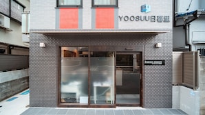 Un edificio con facciata in tegole, ingresso in vetro e insegna con su scritto "Regency nippon".