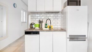 A kitchen with white cabinets, a dishwasher, a microwave, and a sink with various utensils. - Holiday Apartment "Soleole1" with Shared Terrace & Wi-Fi (Gandia)